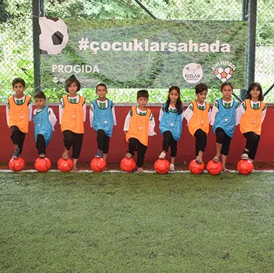 A group of kids standing in a line with a ball