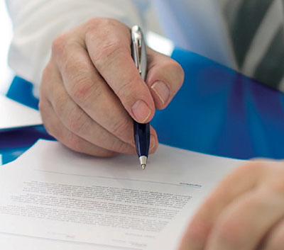 A hand holding a pen over a document