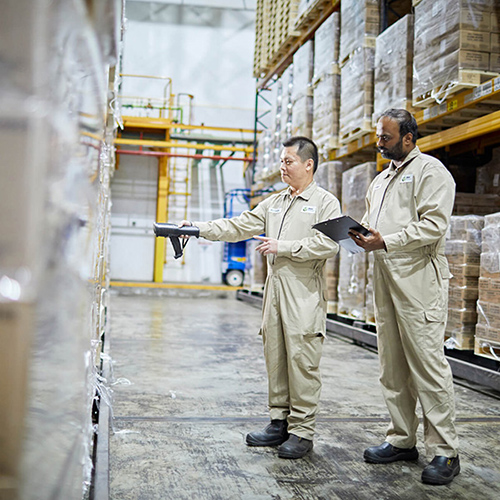 Two male warehouse workers inspecting shelves