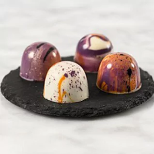 Shot of four colourful cocoa-based bonbons