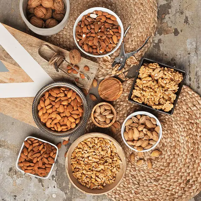 Top view of bowls filled with almonds and pecan nuts