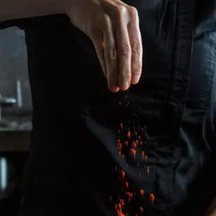 Chef tossing red seasoning