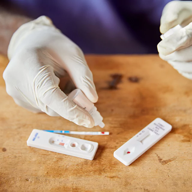 Person wearing surgical gloves doing a two corona tests