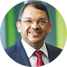 Close-up photograph of Sunny Verghese's face on a green background 