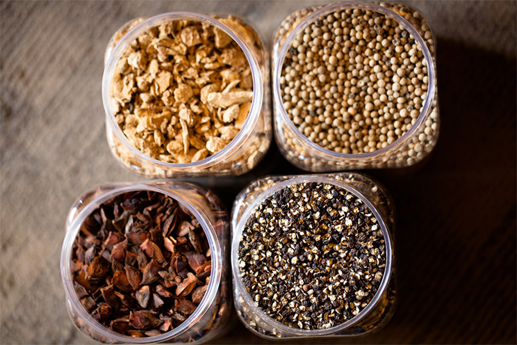 High angle shot of four containers filled with seeds and spices