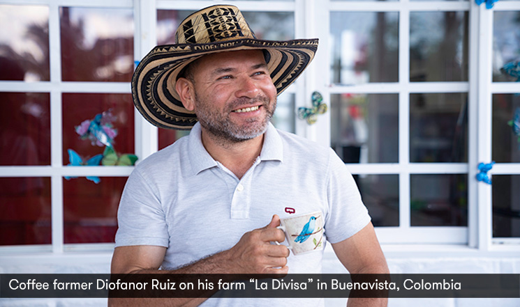 Coffee farmer Diofanor Ruiz wearing hat and posing with coffee cup on his farm "La Divisa"in Buenavista, Colombia