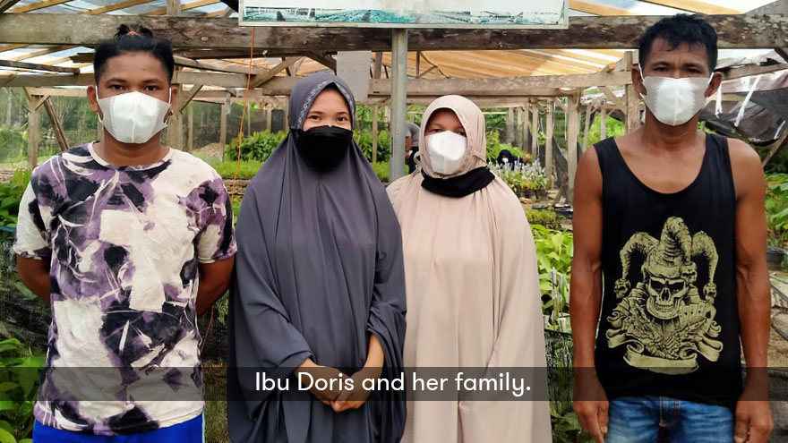 Ibu Doris and her family wearing masks and posing for the photo