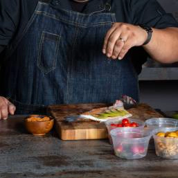 A chef sprinkling chaat masala seasoning over food