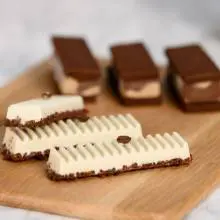 White and brown chocolate bars served on a wooden plate