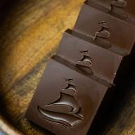 Pieces of dark chocolate with a boat imprint