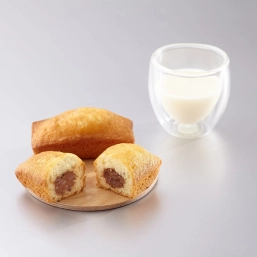 Two pieces of filled cakes served with a cup of milk on the side
