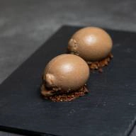 Two scoops of chocolate dessert on a stone plate