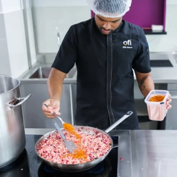 Ofi chef adding spices to the pan