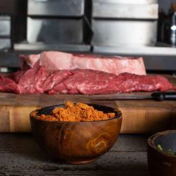 Orange-toned spice mix in a small wooden bowl
