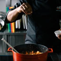 A chef sprinkling seasoning over food