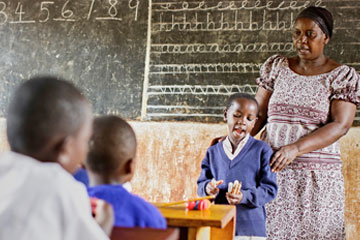 Teacher standing with a child in a classroom