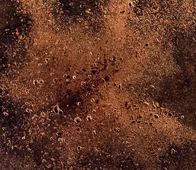 Close-up of a textured surface with cocoa powder and small bubbles