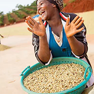 A happy farmer holding a filled basket with produce