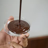 Liquid chocolate falling into a cup