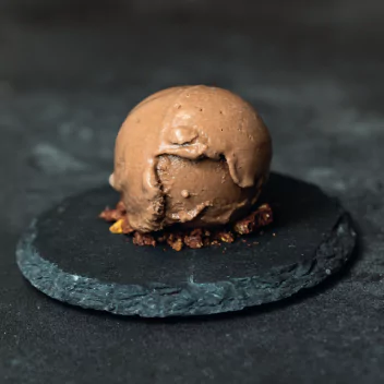 A scoop of ice cream served on a stone plate