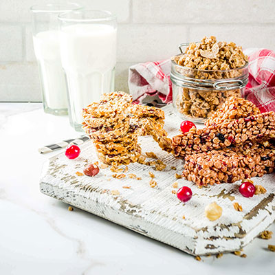 Styled shot of nut bars stacked on top of each other garnished with red berries