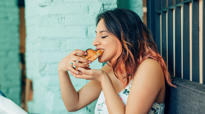 Woman taking a bite of a croissant