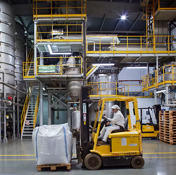 Worker on a yellow painted forklift carrying Macao product in warehouse