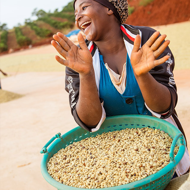 Smiling female farm worker holdings her hands up