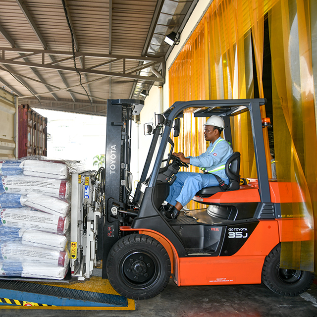Worker driving a forklift and transporting goods