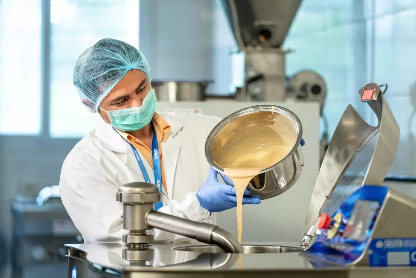 Man pouring liquid substance into a mixer