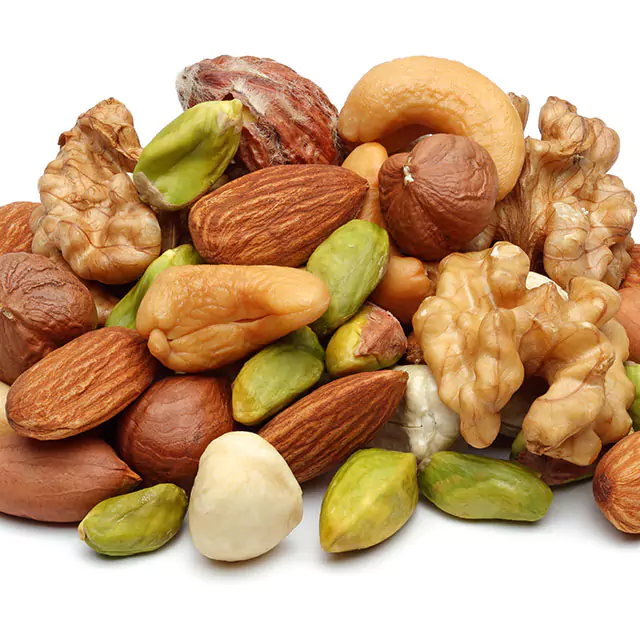 A pile of different raw nuts, such as cashews, hazelnuts, walnuts, almonds, and pistachios