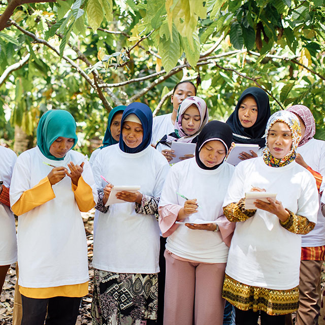 Group of woman standing in a forest and writing on notepads