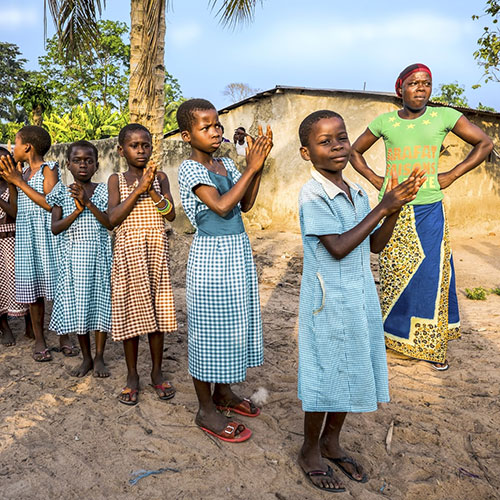 Children clapping hands in a village